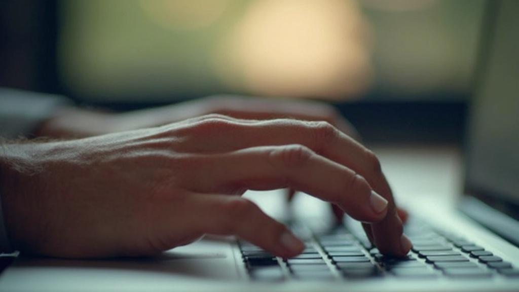 Gros plan sur les mains tapant sur un clavier d'ordinateur