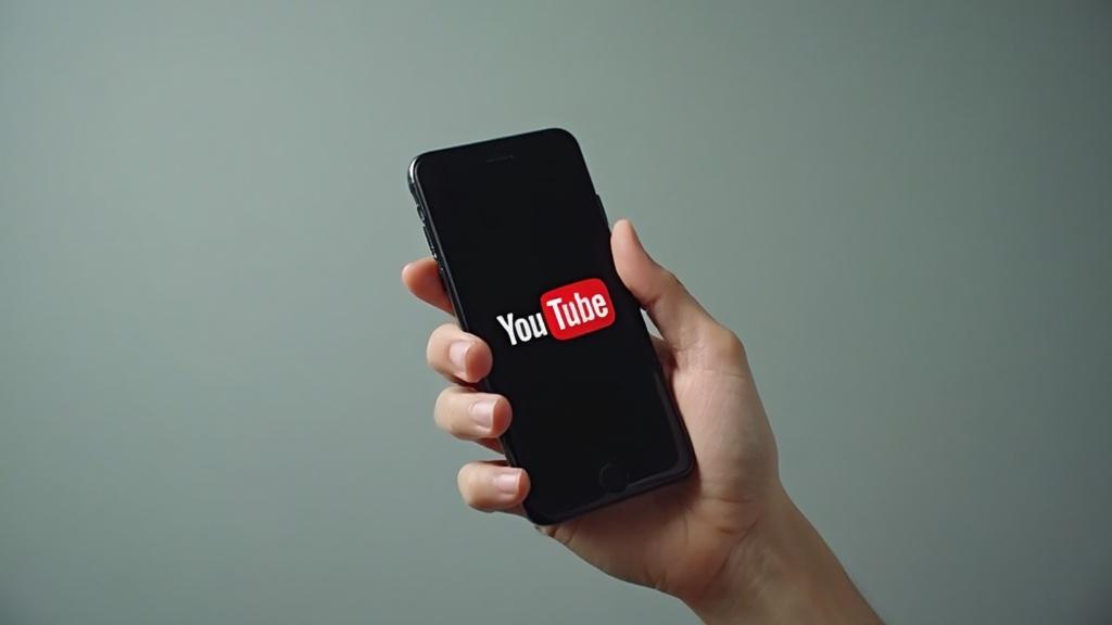 Un smartphone affichant le logo YouTube dans la main d'une personne